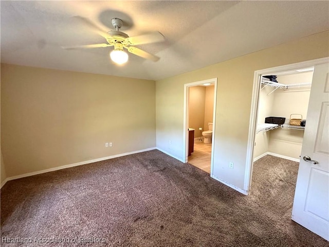 unfurnished bedroom with a walk in closet, ensuite bath, a closet, carpet, and baseboards