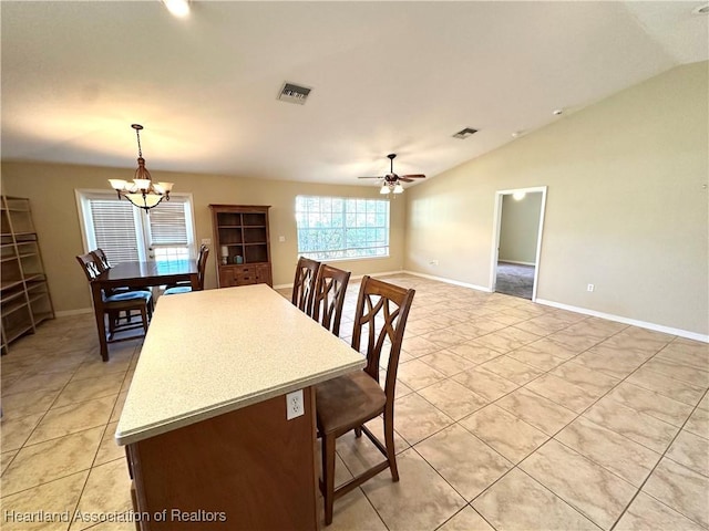 dining area with light tile patterned floors, visible vents, baseboards, vaulted ceiling, and ceiling fan with notable chandelier