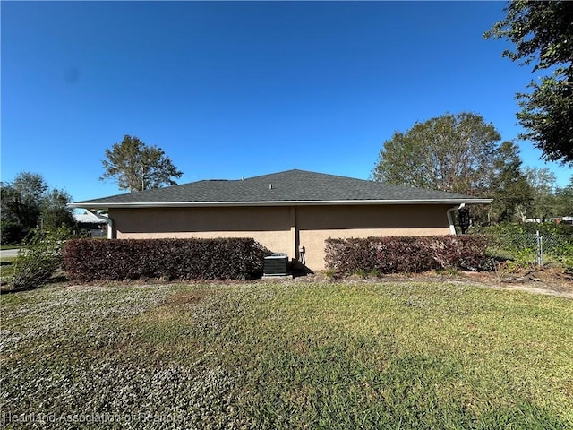 view of property exterior with a yard, central AC unit, and stucco siding