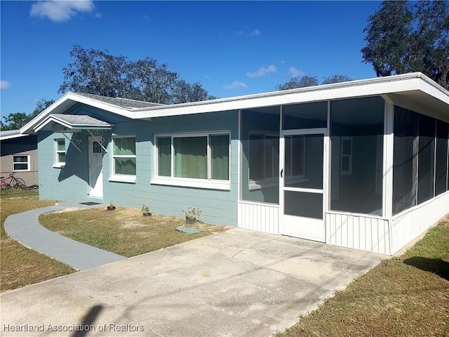 view of front of property with a sunroom and a front lawn