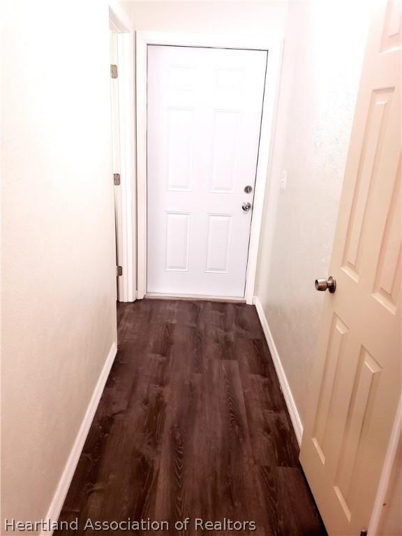 hall with baseboards and dark wood-style flooring