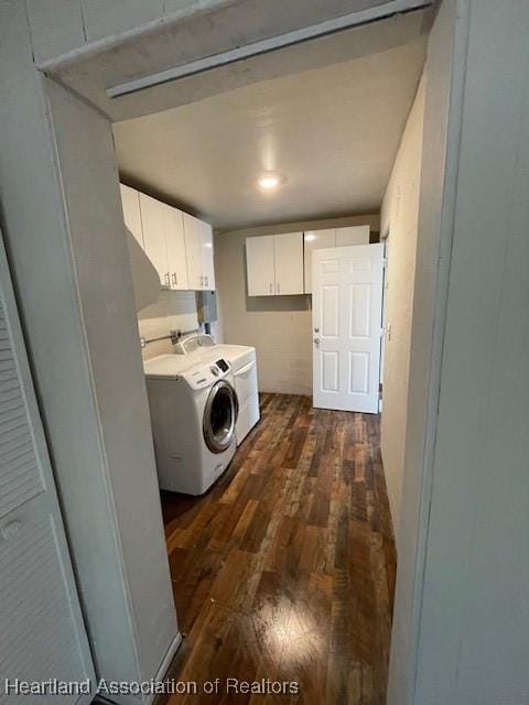 laundry room with washing machine and clothes dryer, cabinets, and dark hardwood / wood-style floors