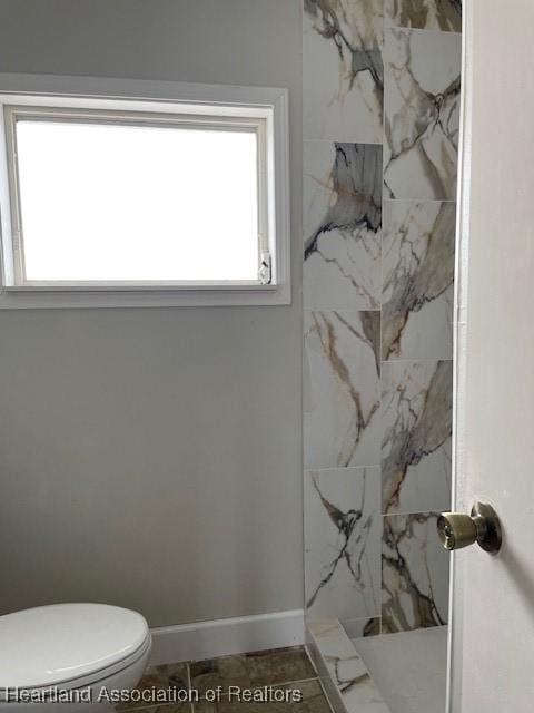 bathroom with toilet, a shower, and tile patterned floors