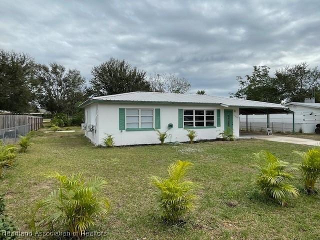 view of front facade featuring a front yard and a carport