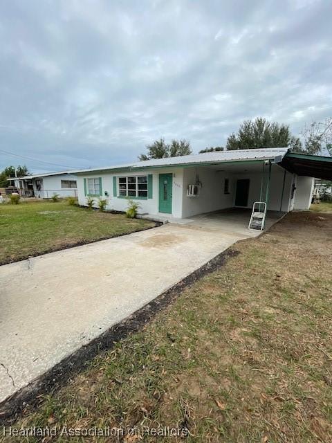 single story home featuring a carport and a front yard