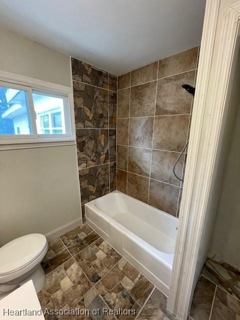 bathroom featuring toilet and tiled shower / bath combo