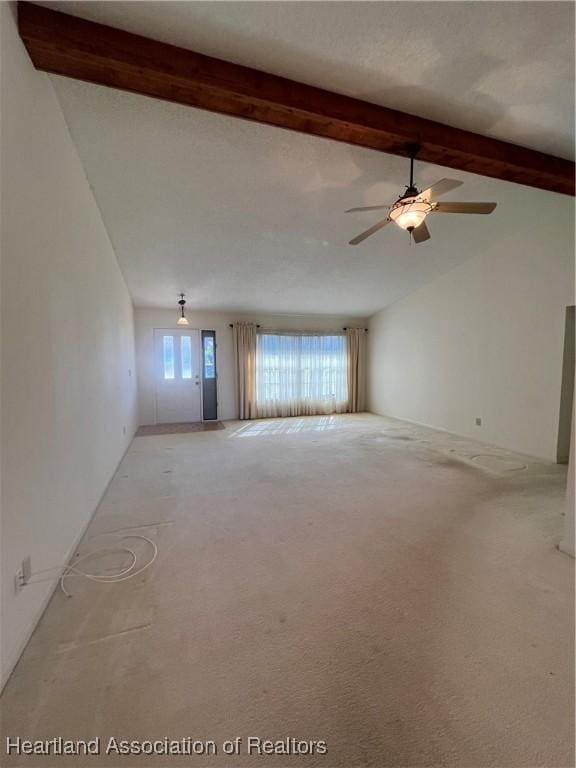 carpeted empty room featuring vaulted ceiling with beams and ceiling fan