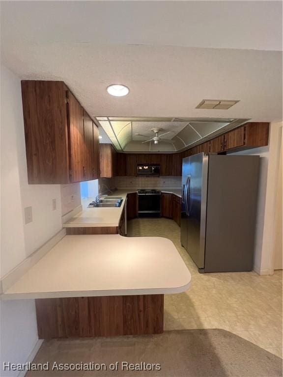 kitchen featuring kitchen peninsula, ceiling fan, sink, and black appliances