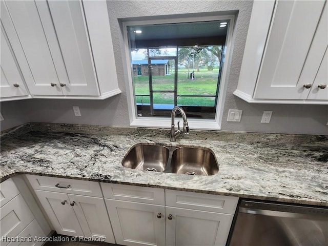 203 Boyer St, Venus, FL 33960 - kitchen with white cabinetry, light stone countertops, dishwasher, and a sink