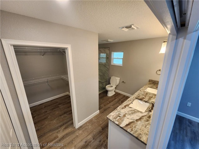 203 Boyer St, Venus, FL 33960 - bathroom featuring tiled shower, vanity, visible vents, baseboards, and wood finished floors