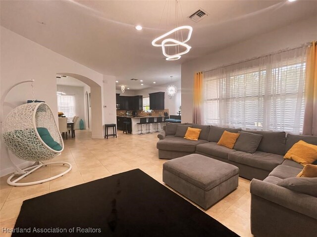 living room with light tile patterned floors and a notable chandelier