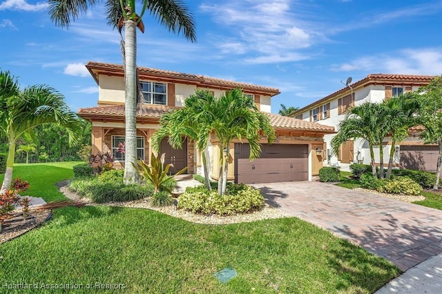 mediterranean / spanish-style home with a front yard and a garage