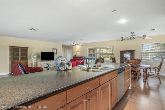 kitchen featuring dishwasher, a sink, visible vents, and a healthy amount of sunlight