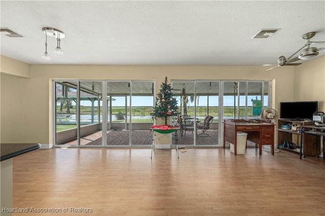 living room with plenty of natural light, visible vents, and wood finished floors