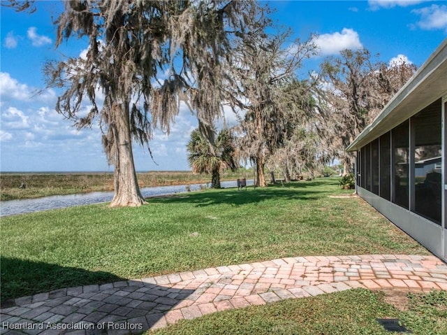 view of yard with a water view and a sunroom