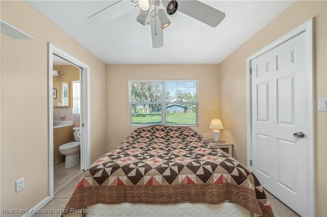 bedroom featuring tile patterned flooring, multiple windows, ceiling fan, and connected bathroom