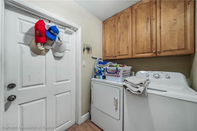 laundry room with cabinet space, baseboards, and washing machine and clothes dryer