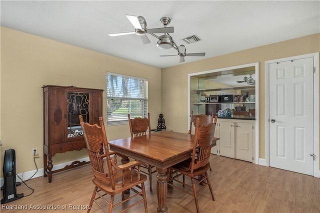 dining area featuring light wood finished floors, baseboards, visible vents, and a ceiling fan