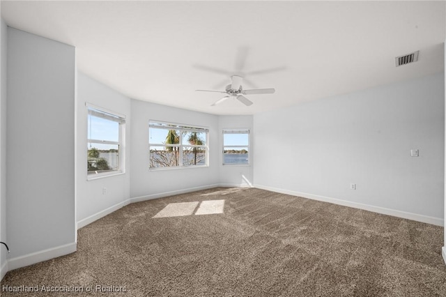 spare room featuring ceiling fan and carpet