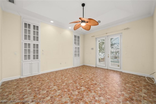 unfurnished room with crown molding, a raised ceiling, ceiling fan, and french doors