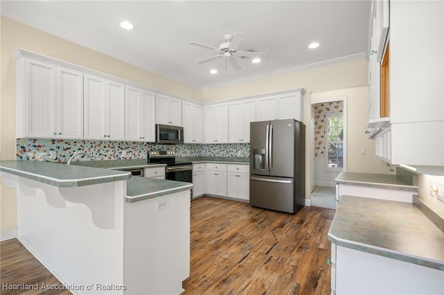 kitchen with stainless steel appliances, white cabinetry, kitchen peninsula, and tasteful backsplash