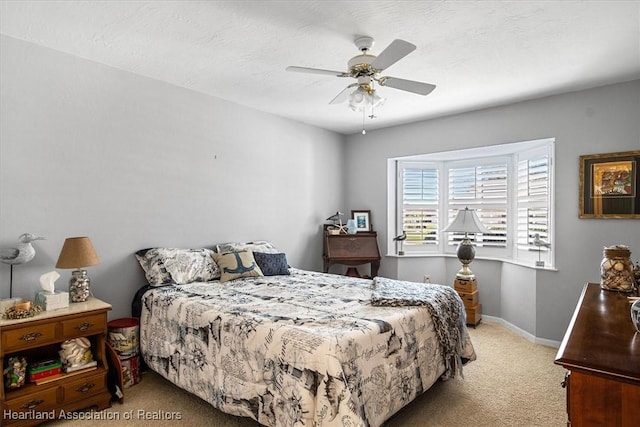 bedroom with ceiling fan, light colored carpet, and a textured ceiling