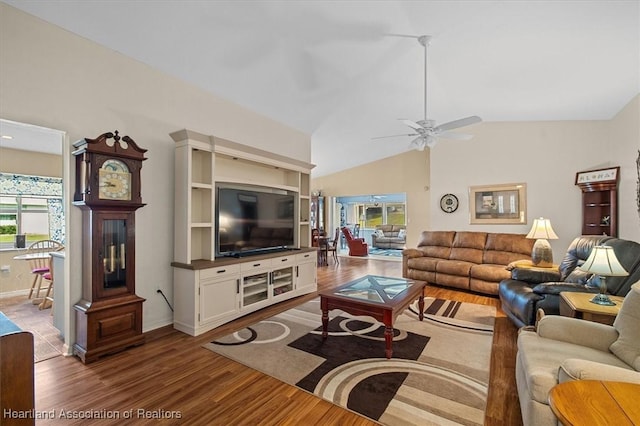 living room featuring wood-type flooring, ceiling fan, and vaulted ceiling