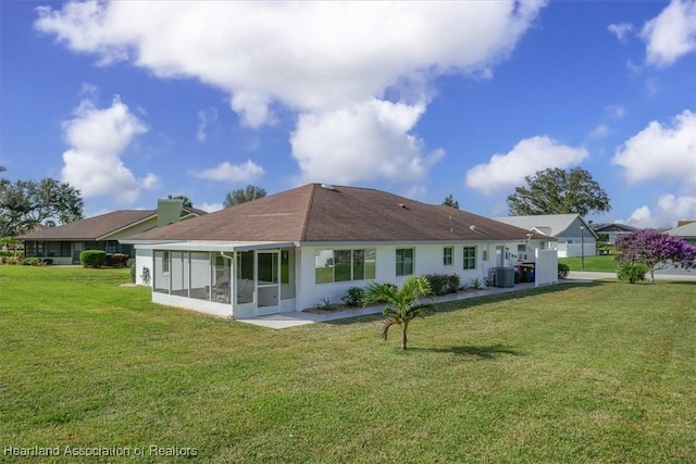 back of property featuring a sunroom, a yard, and cooling unit