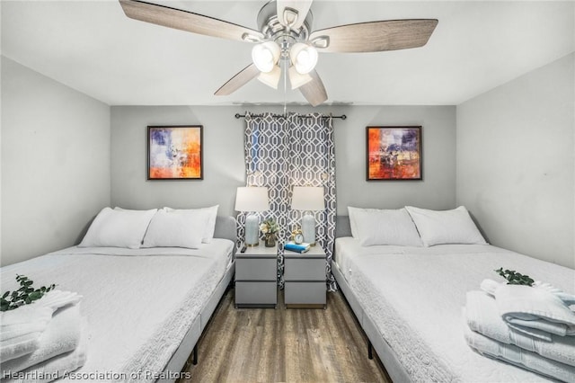 bedroom with ceiling fan and dark hardwood / wood-style floors