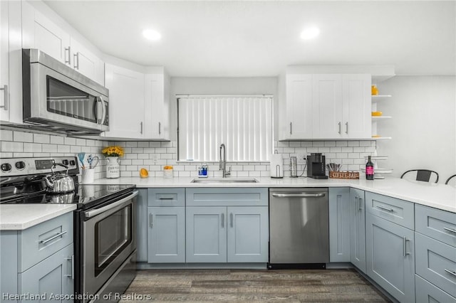 kitchen featuring sink, tasteful backsplash, dark hardwood / wood-style flooring, white cabinets, and appliances with stainless steel finishes