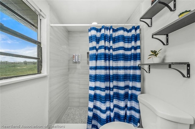 bathroom featuring toilet and walk in shower