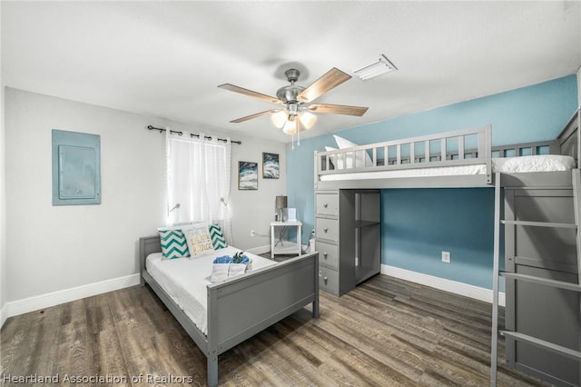 bedroom featuring electric panel, ceiling fan, and dark hardwood / wood-style flooring