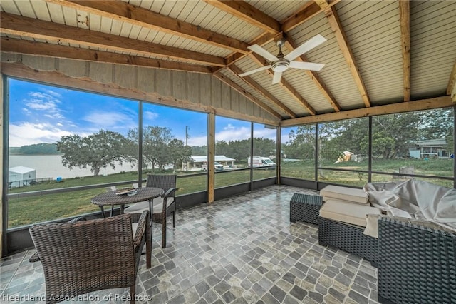 sunroom / solarium featuring vaulted ceiling with beams, ceiling fan, and a water view