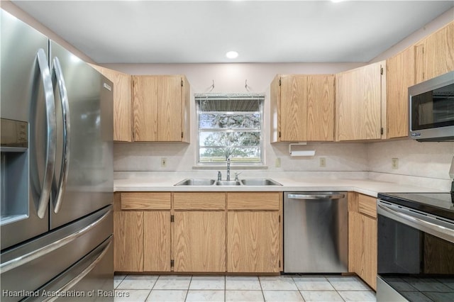 kitchen featuring sink, light tile patterned floors, stainless steel appliances, and light brown cabinetry