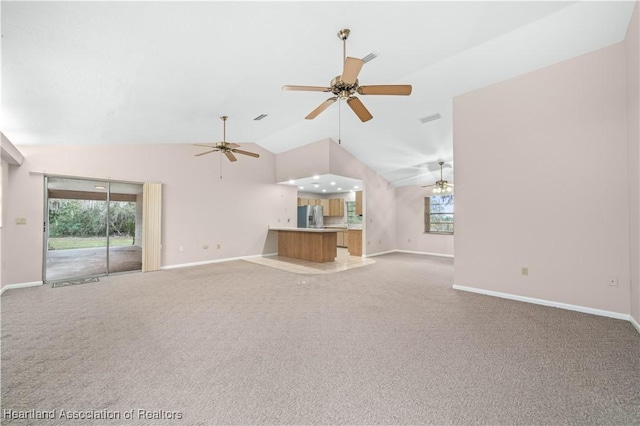 unfurnished living room with carpet, plenty of natural light, and lofted ceiling