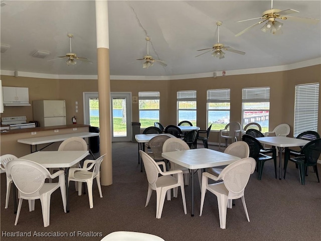 dining room with lofted ceiling, carpet, a ceiling fan, and crown molding