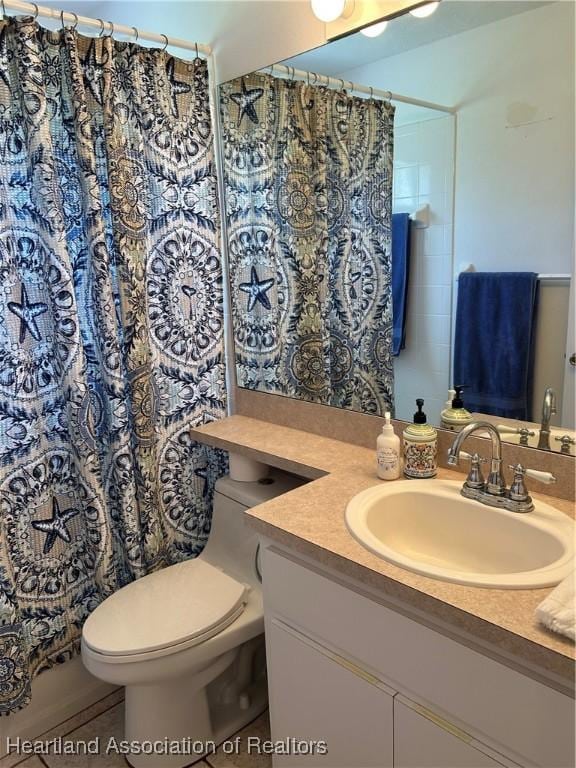 bathroom with toilet, a shower with shower curtain, and vanity