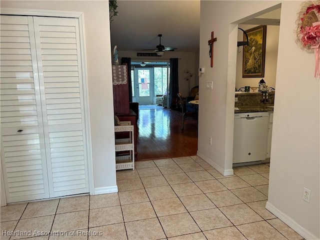 corridor featuring light tile patterned floors and baseboards