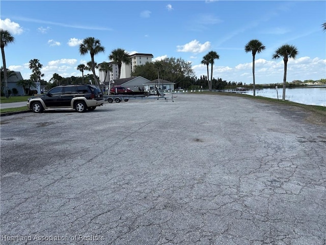 uncovered parking lot featuring a water view