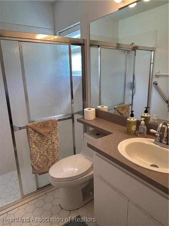 full bathroom featuring a stall shower, vanity, and toilet