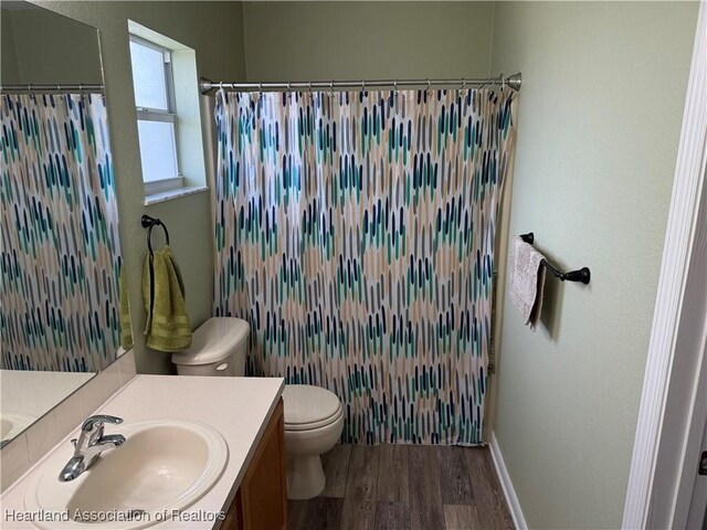 bathroom with vanity, curtained shower, toilet, and wood-type flooring