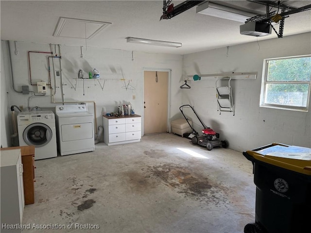 garage with washing machine and dryer and a garage door opener