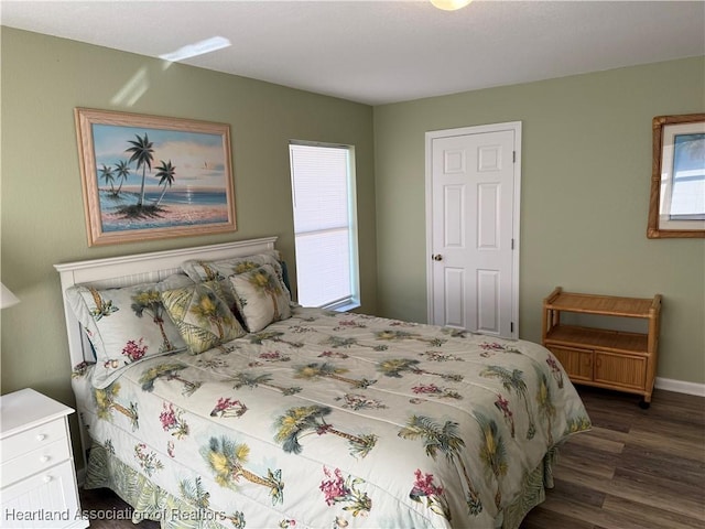 bedroom with dark hardwood / wood-style floors and multiple windows