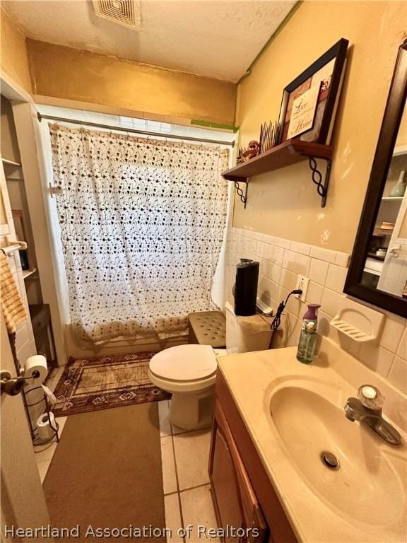 bathroom featuring vanity, tile patterned floors, tile walls, and curtained shower