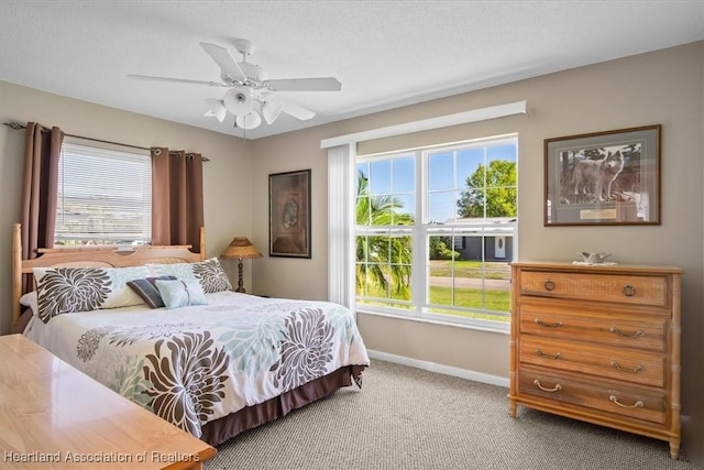 bedroom with light colored carpet, baseboards, and ceiling fan