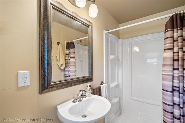 bathroom featuring curtained shower and a sink