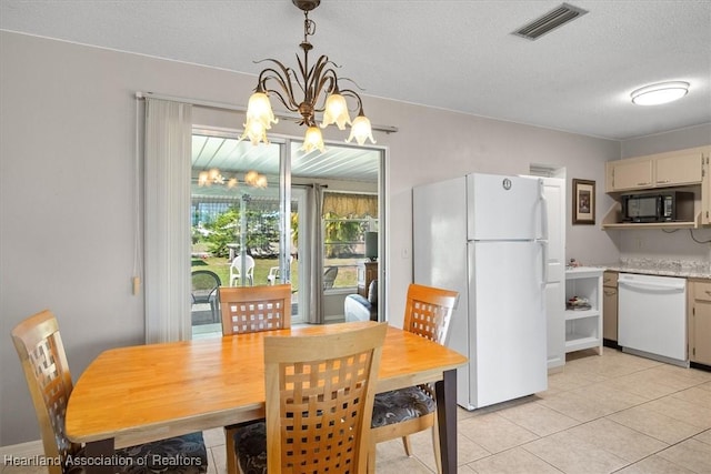 dining space with light tile patterned flooring, visible vents, a textured ceiling, and an inviting chandelier