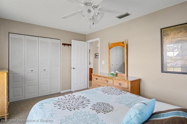 carpeted bedroom featuring visible vents, a closet, and ceiling fan