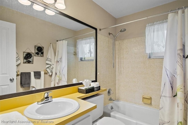 bathroom with toilet, vanity, and shower / tub combo