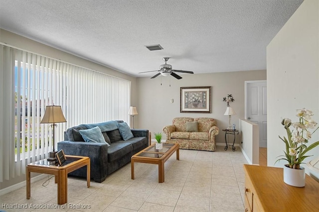 living area with light tile patterned floors, visible vents, and a healthy amount of sunlight